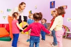 Teacher and group of kids in kindergarten